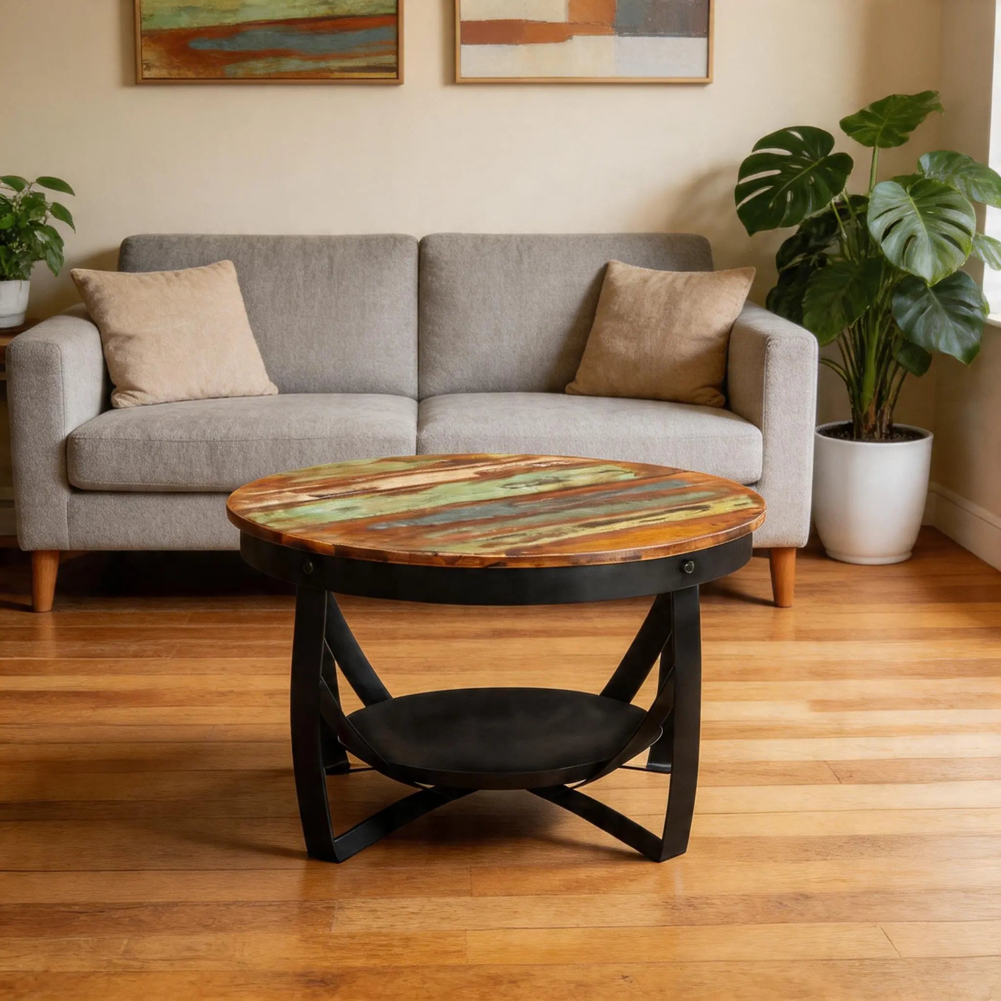 Table basse ronde en bois recyclé multicolore avec structure en métal noir, mise en scène dans un salon au style industriel Image