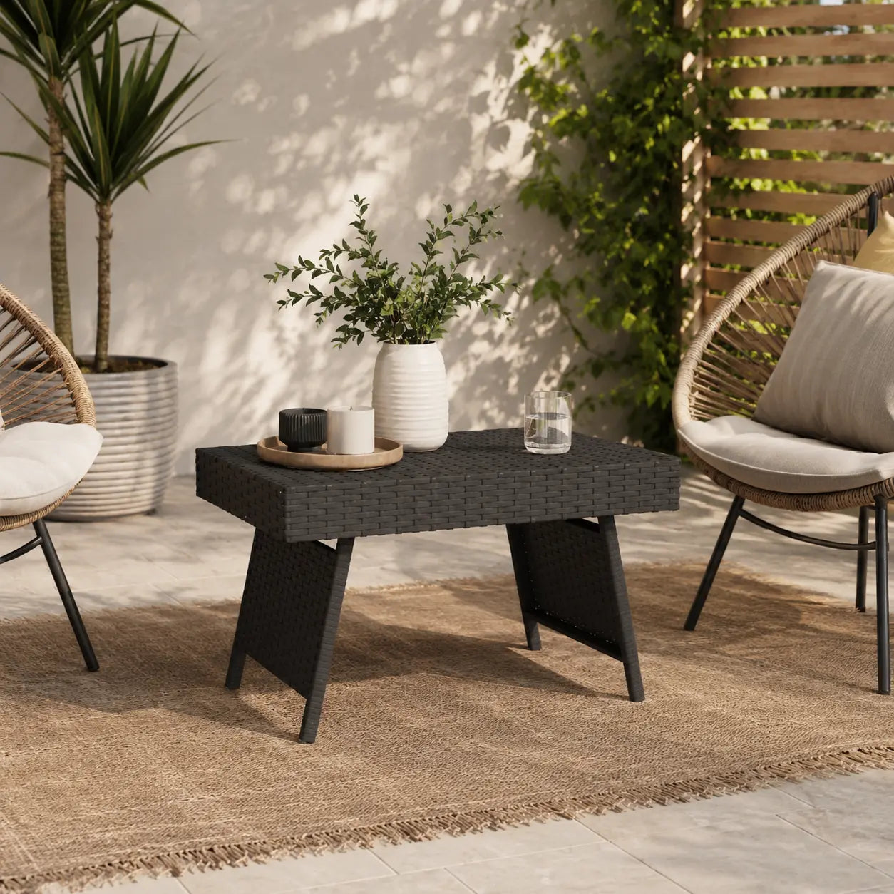 Table basse extérieure en résine tressée noire sur terrasse moderne avec ambiance jardin élégante Image