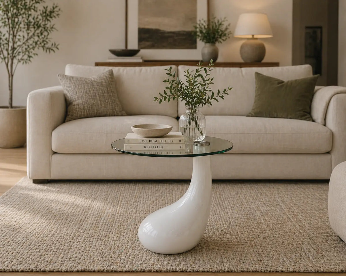 Table basse design avec plateau en verre rond et base sculpturale blanche, style moderne pour salon élégant