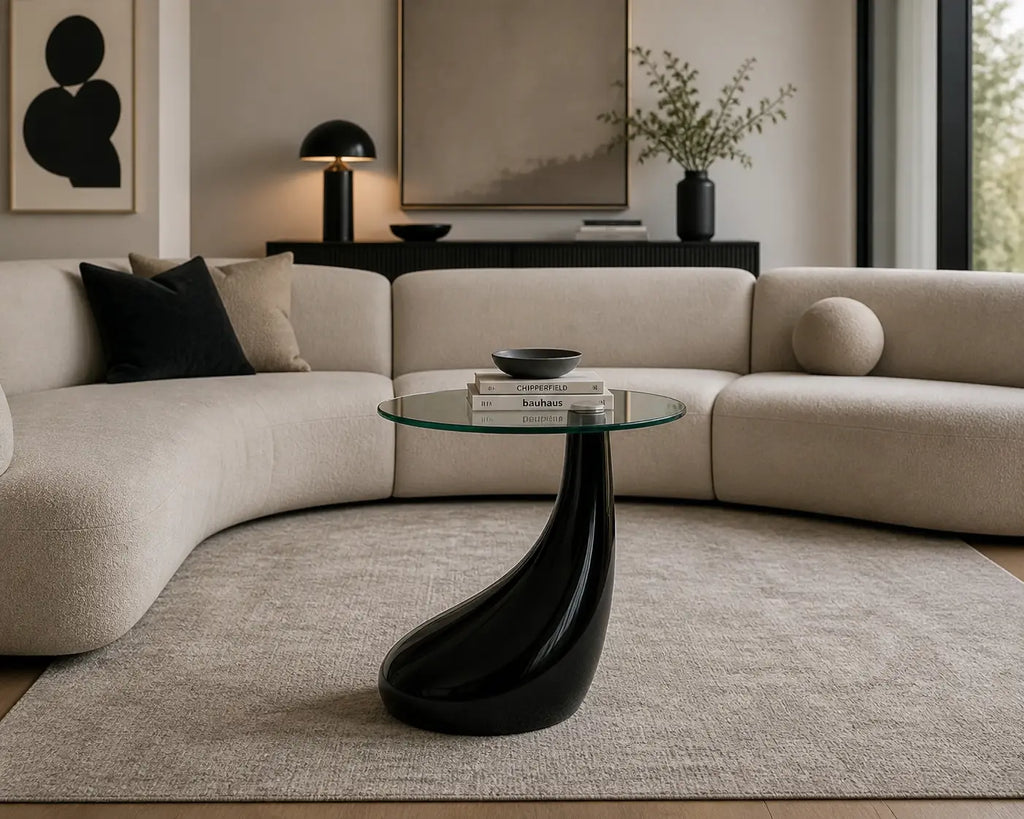 Table basse Norin en verre rond avec base noire sculpturale dans un salon moderne et minimaliste
