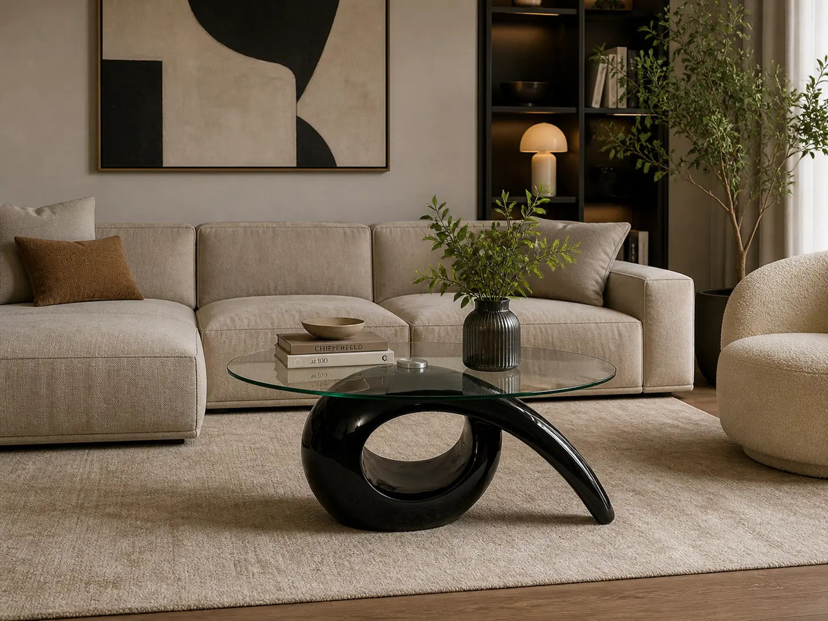 Table basse design avec plateau en verre rond et base noire sculpturale dans un salon contemporain élégant