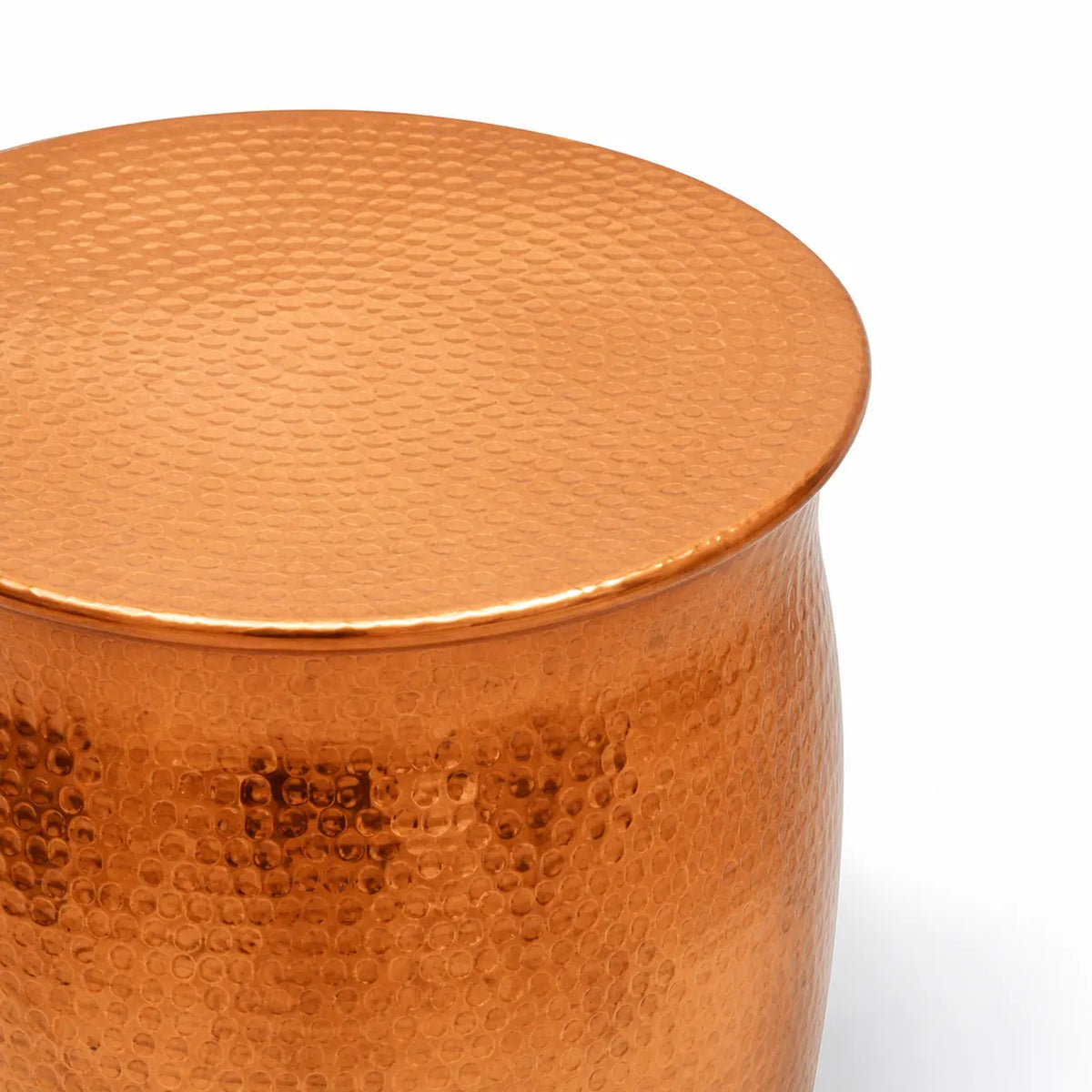 Gros plan sur table basse cuivrée martelée, finition métallique texturée brillante au design contemporain